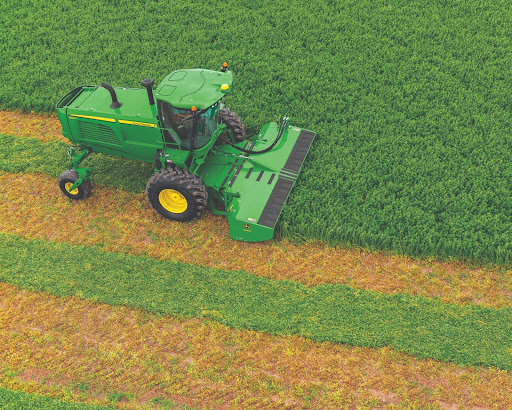 John Deere clearing the field