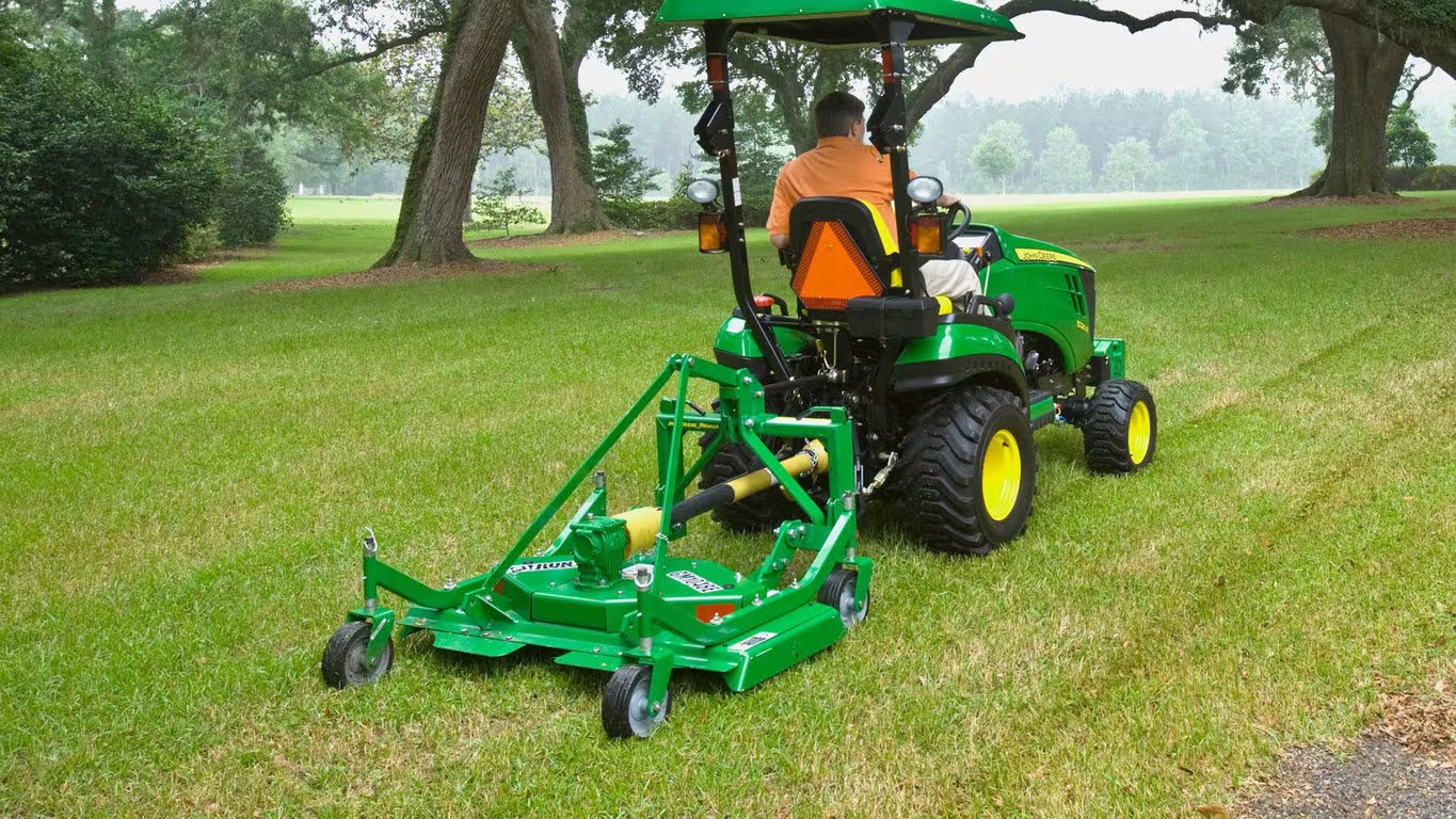 John Deere tractor with a mowing implement attached.