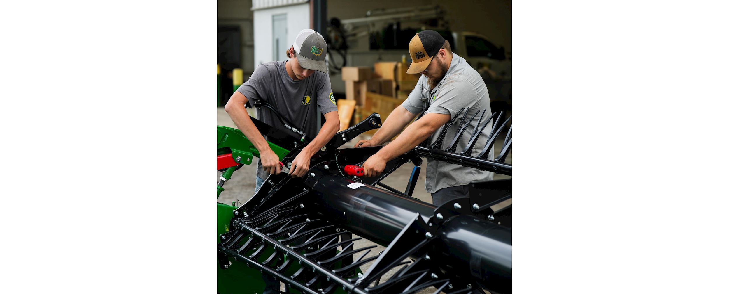 Two of Ag-Pro's John Deere ag tech students work on equipment.