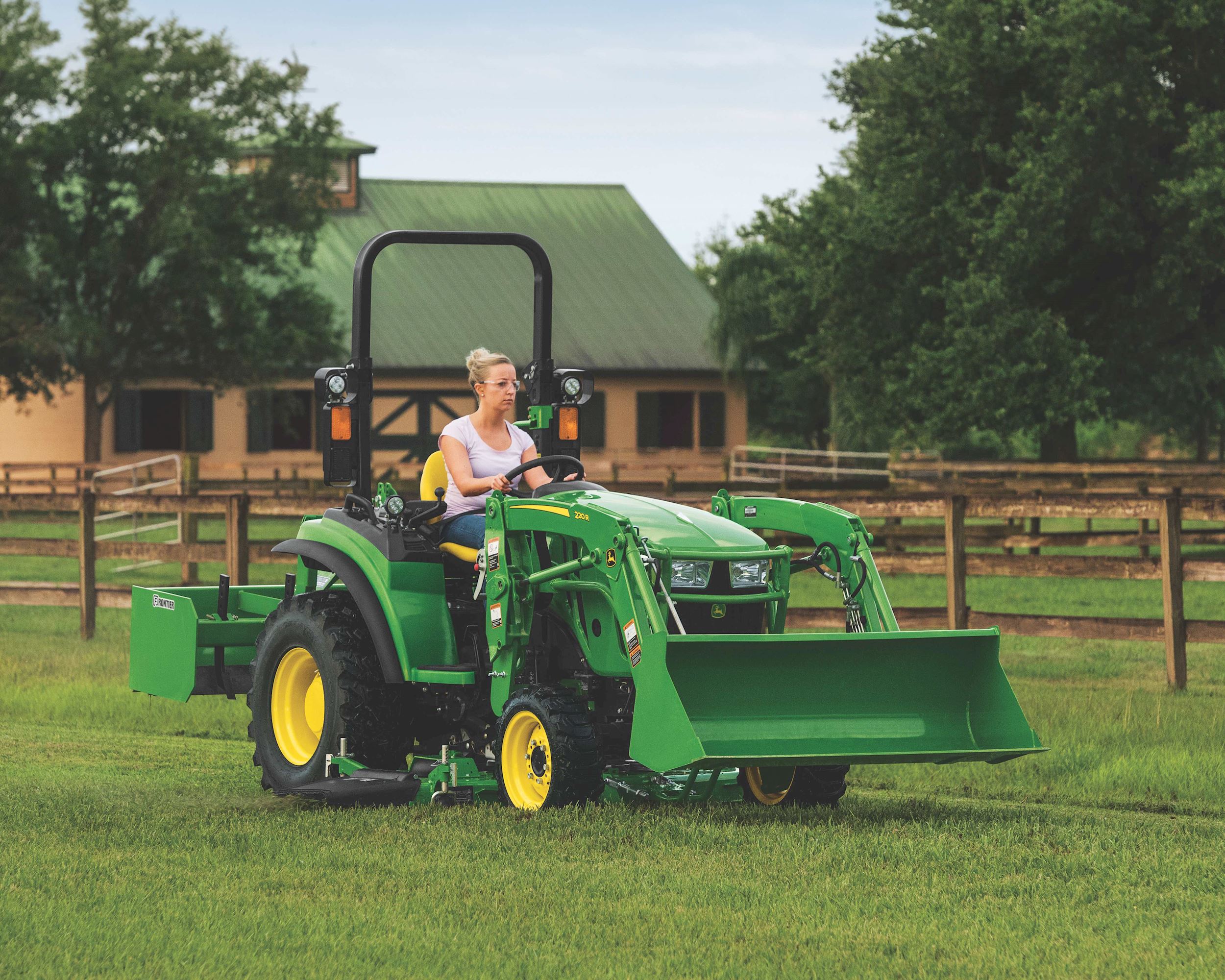 Woman driving a 2038R John Deere tractor.
