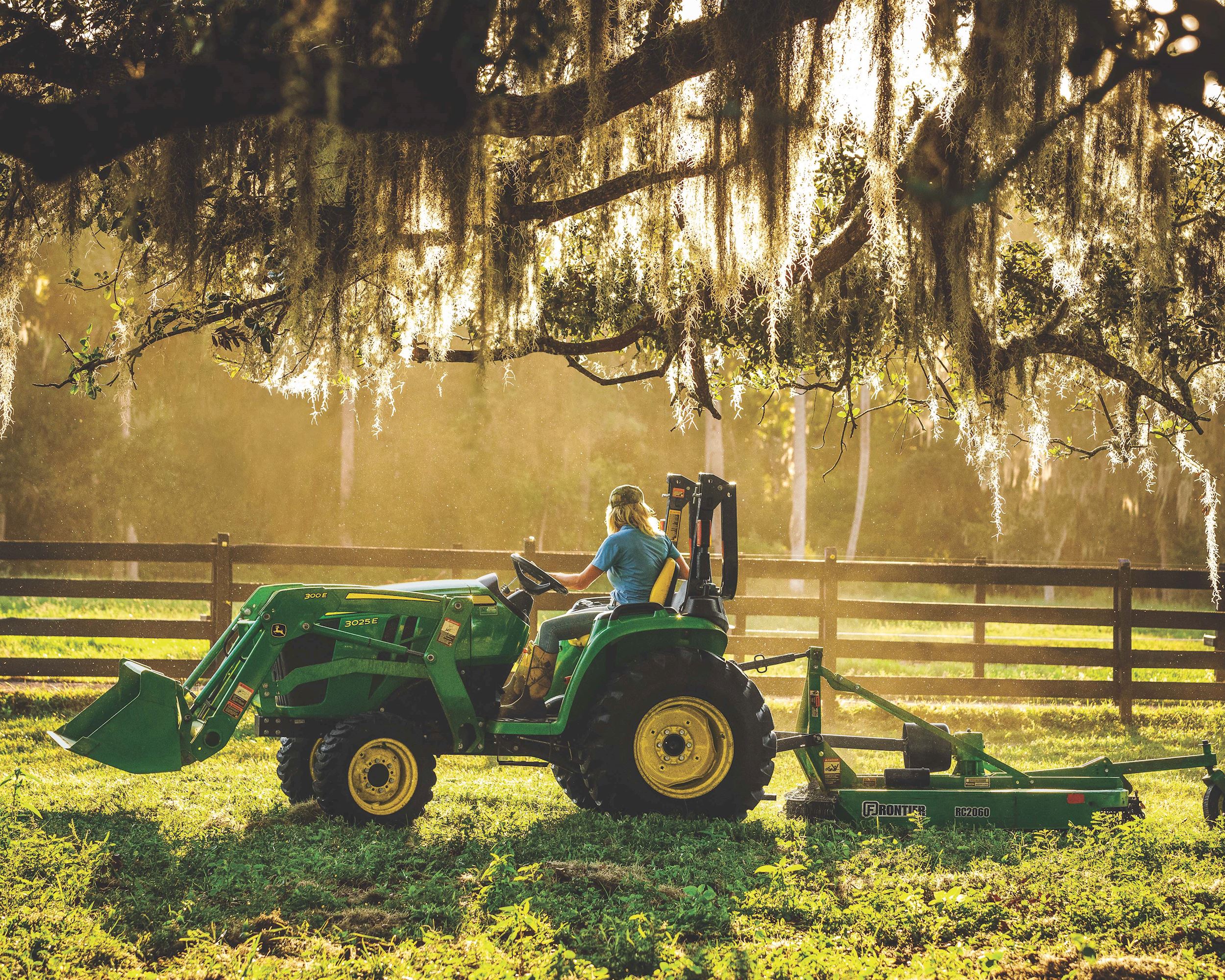Woman driving 3025E John Deere Compact Tractor