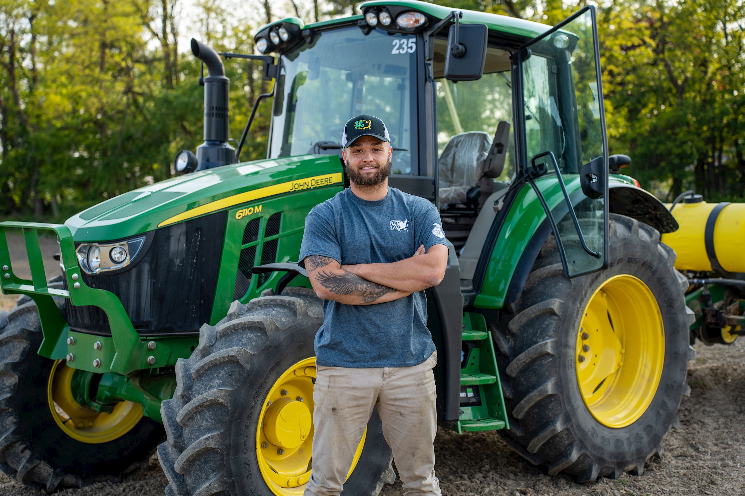 Cade Stover in front of John Deere tractor